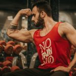man in red tank top sitting on chair